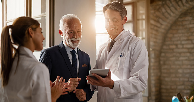 DOCTOR SHOWING MAN IN SUIT HIS IPAD