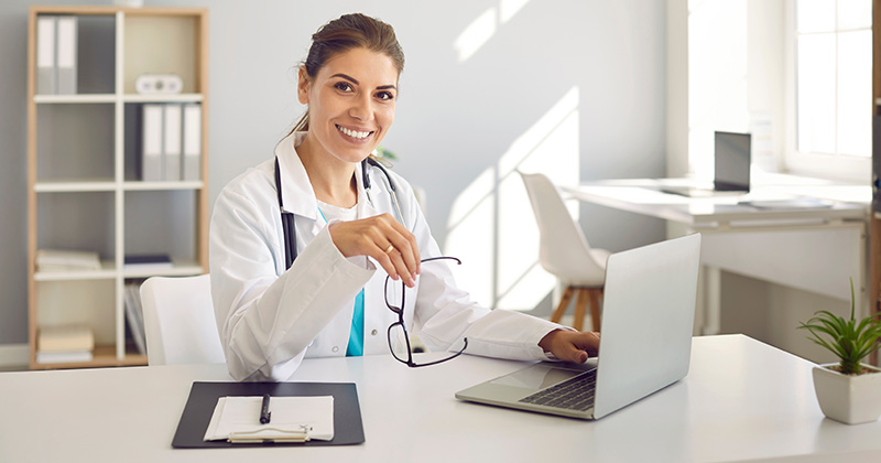 female practitioner sits at computer