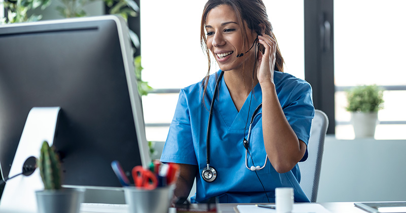 NURSE IN SCRUBS USING TELEHEALTH INTEGRATION