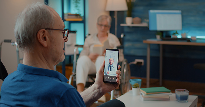 OLDER MAN USING PHONE FOR TELEHEALTH