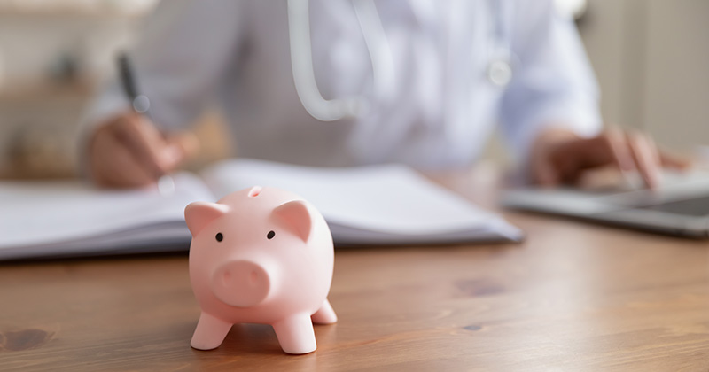 B2 - Piggy bank with doctor in background