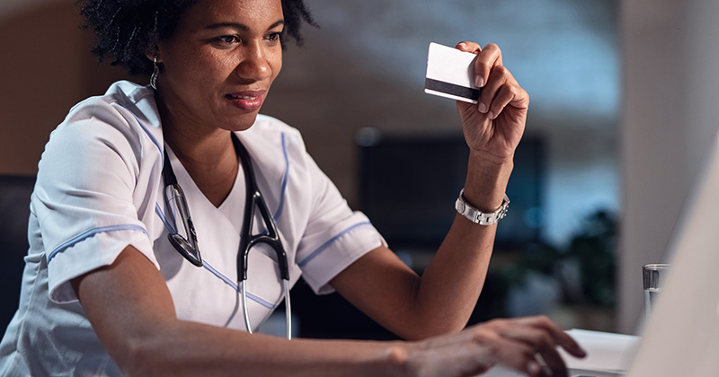 WOMAN IN SCRUBS HOLDING CREDIT CARD